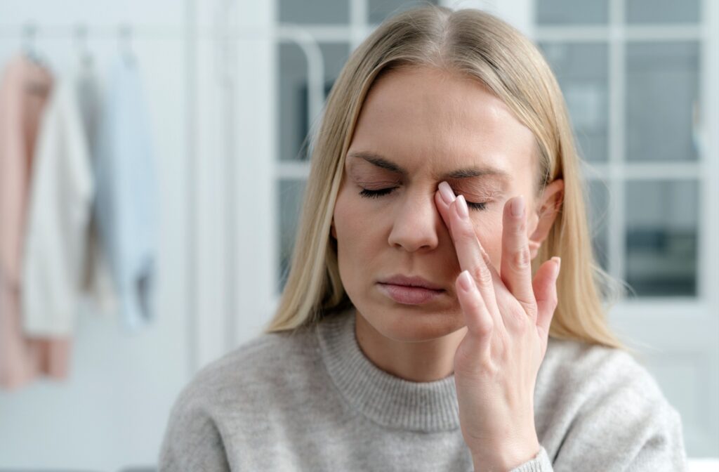 A person rubbing their eyes due to dry eye symptoms with inadequate contact lenses.