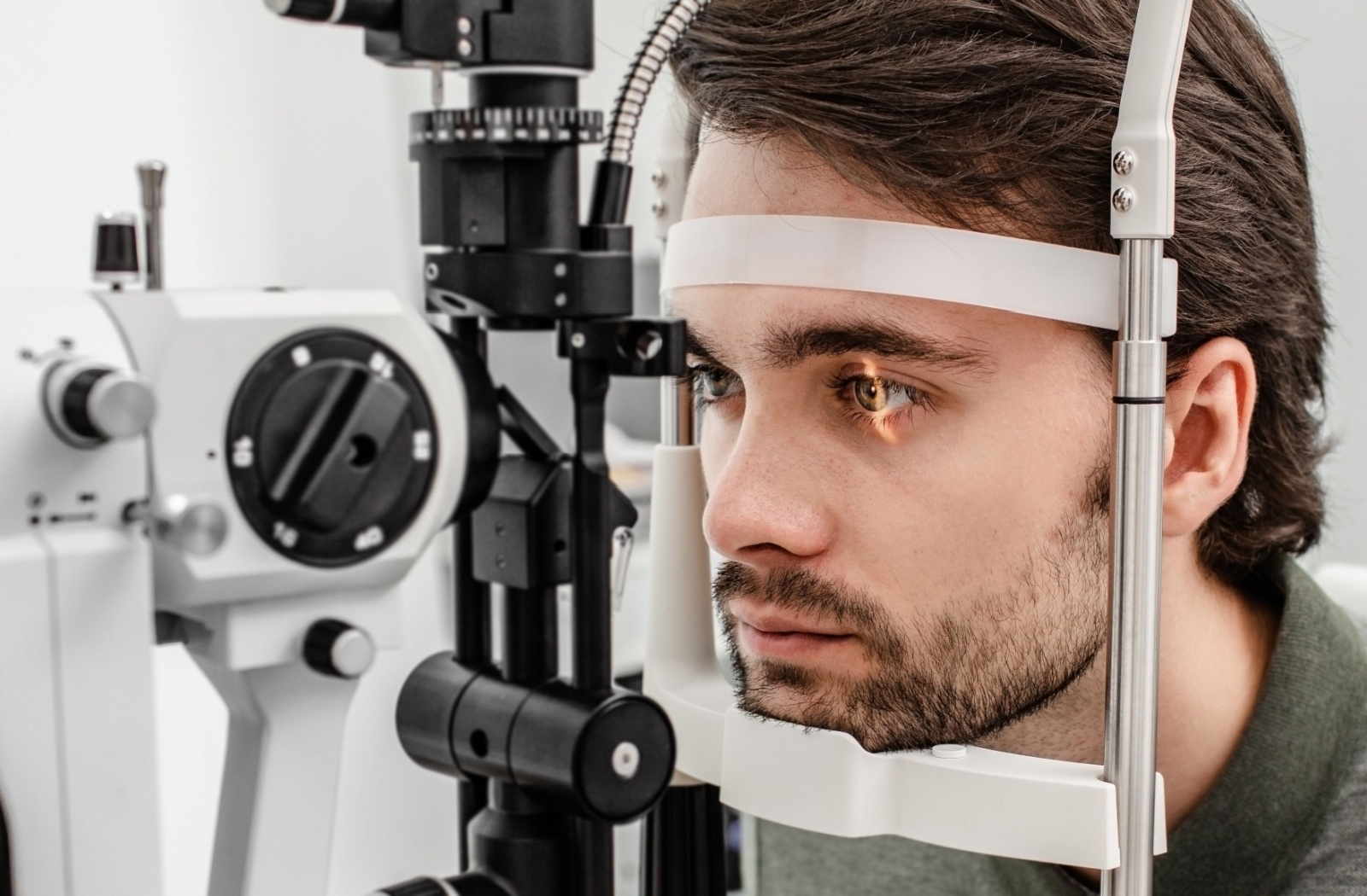 A close-up image of a patient during a slit-lamp eye exam to check their retina.