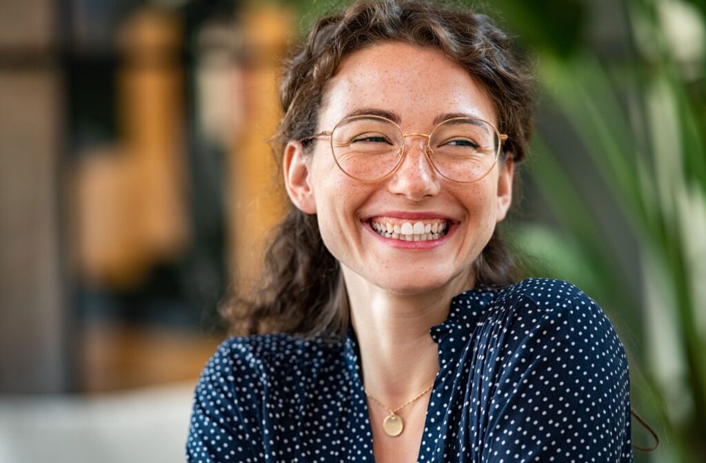 A person smiling while wearing a pair of sleek thin framed glasses